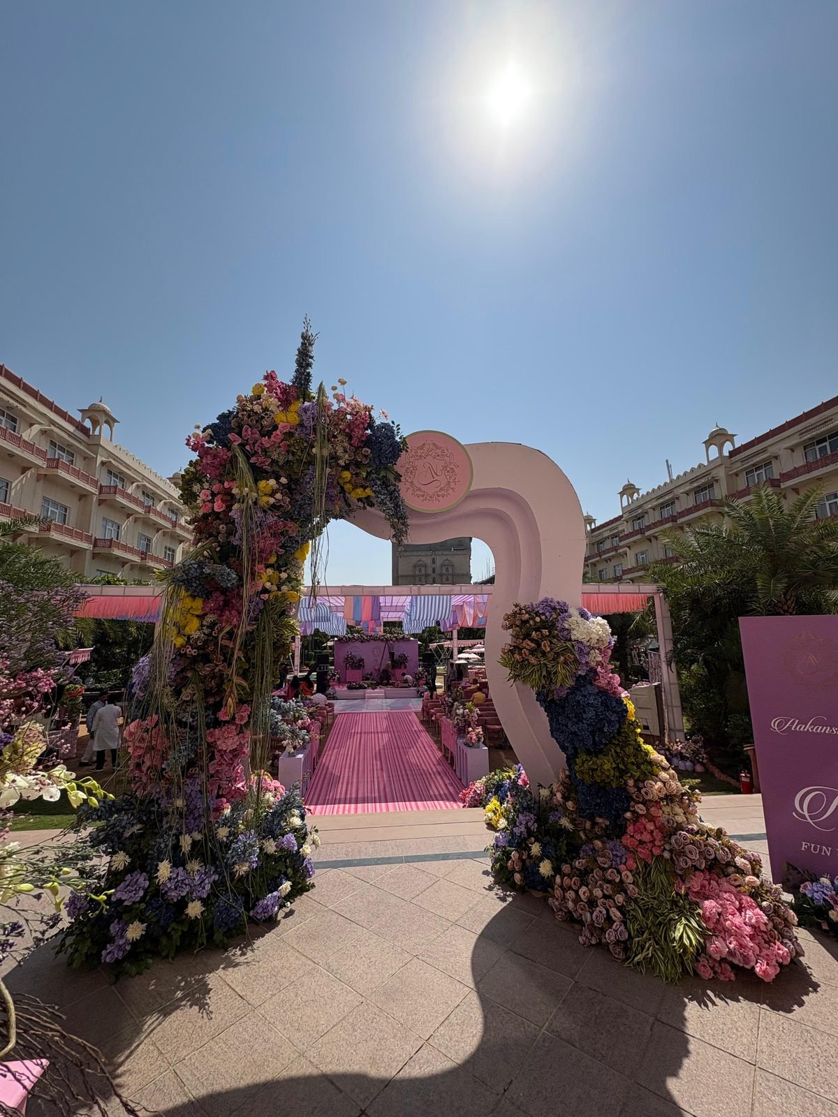 Floral entrance arch leading to the wedding aisle at a palace hotel