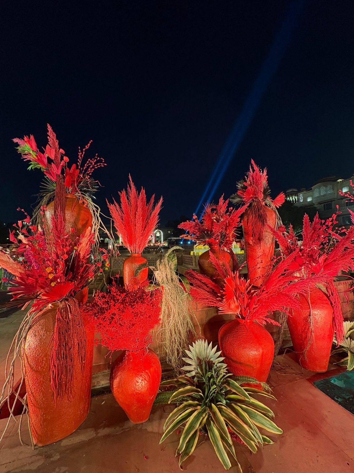 Red floral urn arrangements at an evening heritage venue